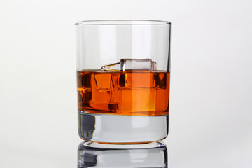 Whiskey with ice in glass beaker on