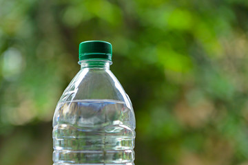 Plastic bottle of clear water in green environment