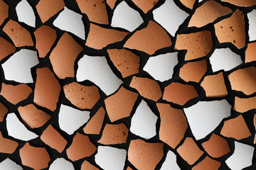 Broken eggshell shards on black. Brown and white pieces texture. Abstract creative background. Closeup