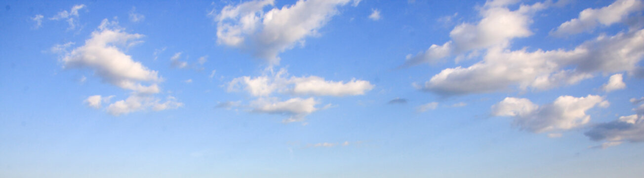 Panoramic view of blue summer sky with white clouds or cloudscape.