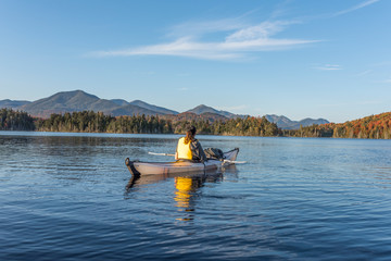 Wilderness woman enjoying the view of the Adirondacks from her white kayak