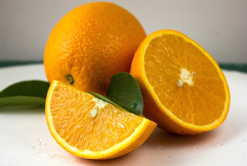 Fototapeta na wymiar Orange fruit with orange slices and leaves on white background.
