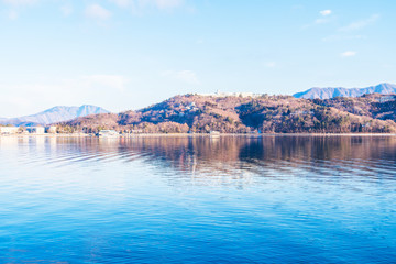 View of Yamanaka water lake with hotel home office in cold morning atmosphere in blue sky with resort of Yamanakako, YAMANASHI Japan