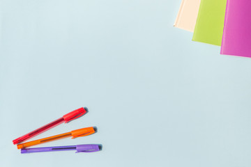 Office supplies or stationery. Multi-colored pens and notebooks. Top view, with copy space.