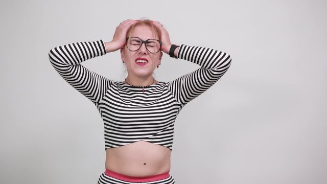 Teenager girl with striped shirt has realized something and intending the solution wearing casual clothes keeping hand near head, looking shocked