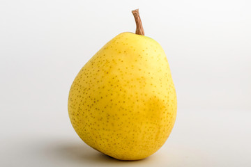 One fresh organic ripe yellow pear on table, isolated on white background, side view with soft focus of tasty healthy food