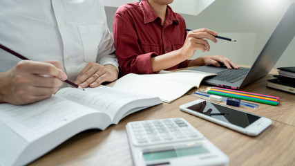 Teaching helping technology concept. Woman young teacher or tutor with adult students in classroom...