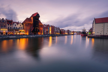 Old town and medieval crane in Gdansk evening cityscape.