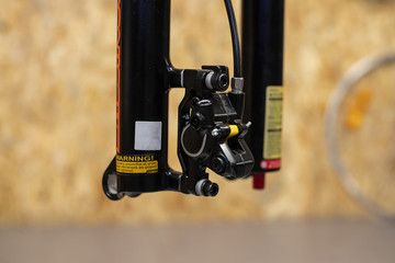 Close up photo of front hydraulic disc brake calliper during brake bleeding process. A bleeding...