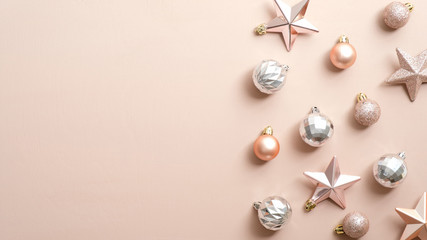 Top view stylish Christmas decorations on ivory background. Flat lay silver and pink Xmas balls and stars. Winter holiday postcard template, New year banner mockup. Minimal style festive composition