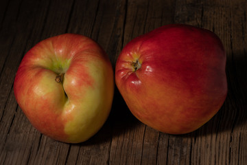 Two textured ripe apple on old wood