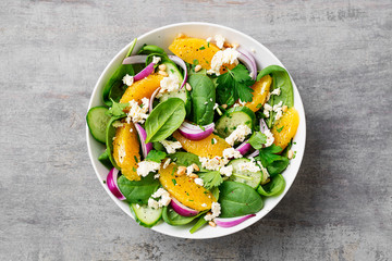 Fresh spinach salad with oranges, feta (ricotta) cheese, red onion and pine nuts .
