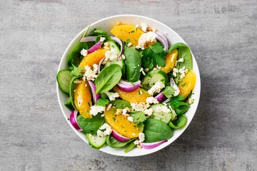 Poster Fresh spinach salad with oranges, feta (ricotta) cheese, red onion and pine nuts . © Nelea Reazanteva