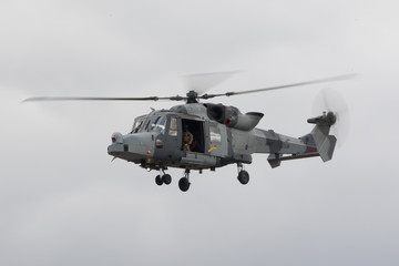 Lynx army helicopter flying with door open and blurred rotors