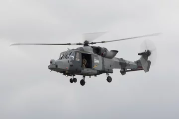 Foto op Plexiglas Lynx-legerhelikopter die met open deur en vage rotors vliegt © Andrew Darkes