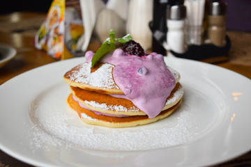 pancakes on a white plate with blueberry sauce