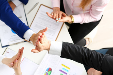 Group of people in suits crossed hands in pile