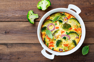 Frittata or casserole with broccoli and vegetables in baking dish. Vegetarian recipe.