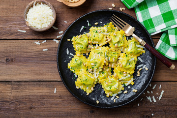 Italian ravioli pasta with spinach and ricotta on  wooden  background. Top view.