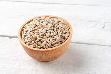 Sunflower seeds in bowl on vintage wooden background