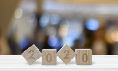 Happy New Year 2020 on wood cube block on white table with blur bokeh light background, For...