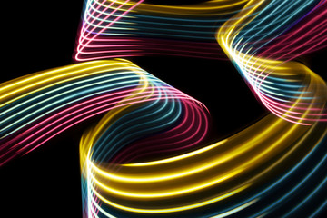 Yellow, pink and blue light curve lines on a black background .