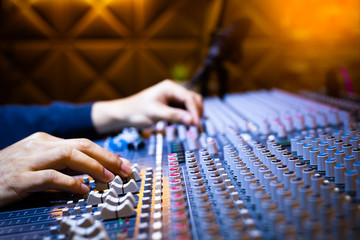 music producer, sound engineer hands working on audio mixing console on recording broadcasting studio. music production, post production, broadcasting concept - obrazy, fototapety, plakaty