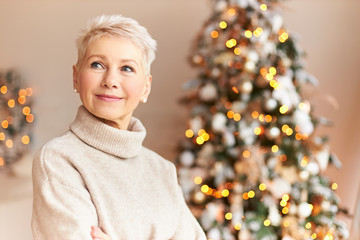 Holiday season, tradition and celebration concept. Attractive sixty year old woman in cozy sweater...