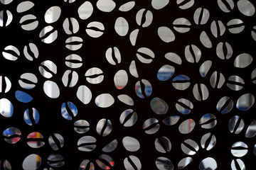 A black wooden wall with coffee seed like perforated design 
