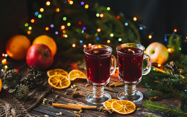 mulled wine in glass glasses with orange slices, apples and spices with Christmas decor