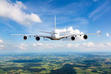 Fototapeta na wymiar White passenger plane in flight. The plane flies against a background of a endless horizon. Aircraft front view.