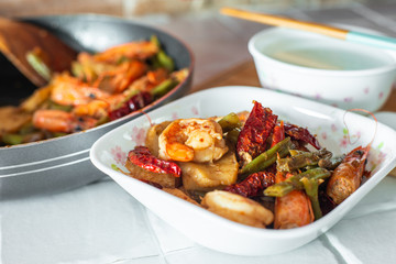 Stir-fried spicy dried chilli french green beans with prawns, and a bowl of porridge.