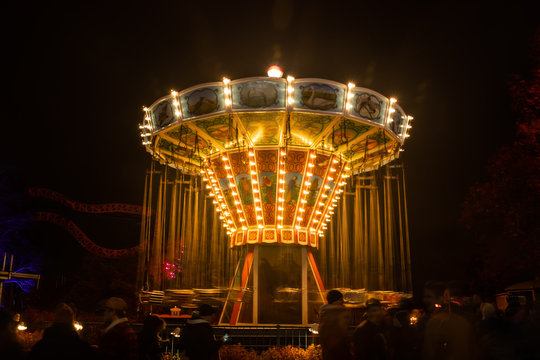 Helsinki, Finland - 19 October 2019: The Carnival of Light event at the Linnanmaki amusement park. Ride chain carousel Ketjukaruselli in night illumination.