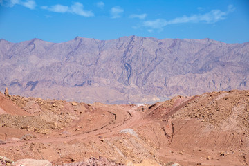 Side view of colorful mountains of Eilat against of blue sky with clouds. Israel