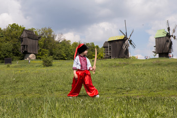 Cute happy boy in Ukrainian national costumes. Portrait of kid in traditional Cossack clothes