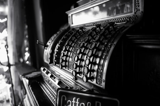 Black and white image of an old 19th century cash register. Selective focus on cashier buttons.