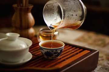At a tea ceremony black tea is poured from a glass into a small Cup