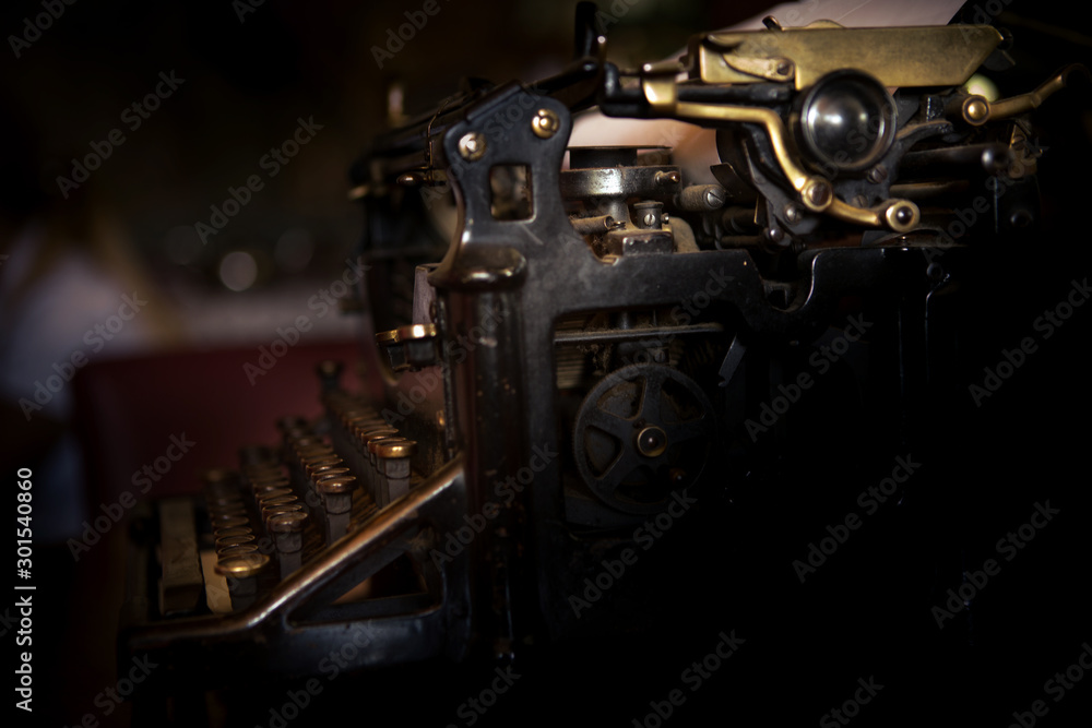 Aufkleber selective focus on the keyboard and mechanism of an old black rustic typewriter on an office desk.