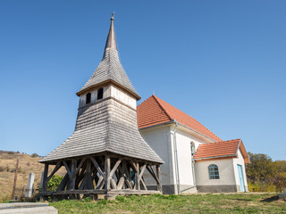 Fototapeta na wymiar Wooden bell tower of a church outside a village in Transylvania, eastern Europe