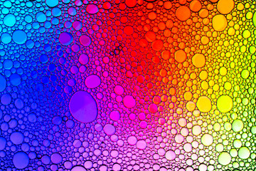 Colorful drops of oil on the water. Rainbow or spectrum colored circles. Abstract bright background...