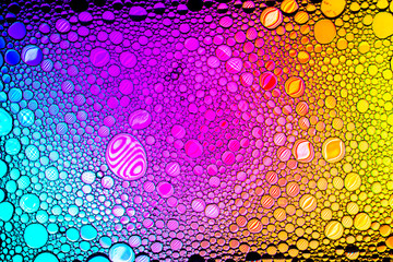 Colorful drops of oil on the water. Rainbow or spectrum colored circles. Abstract bright background...