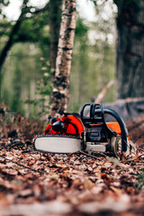 Naklejka premium chainsaw and helmet in the forest, deforestation for logging