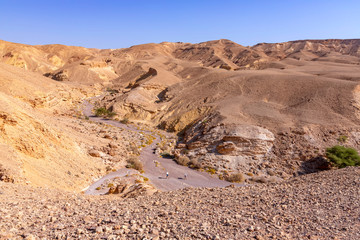 Fototapeta na wymiar View of the colorful mountains and valley of Eilat Red Canyon against the blue sky. Israel