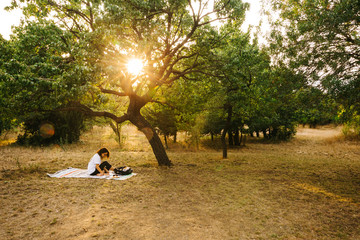 A female model is working/reading in a Public Park at sunset time