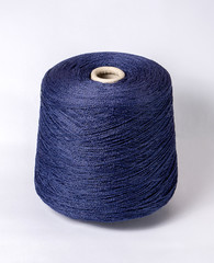 Skein of blue yarn on a white background. Material for the manufacture of knitwear. Side view.Textile reel on isolated white background.