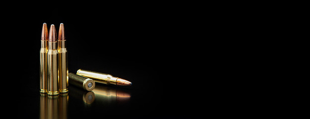 Bullet isolated on black background with reflexion. Rifle bullets close-up on black back. Cartridges for rifle and carbine on a black. - obrazy, fototapety, plakaty