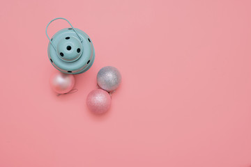 Top view of pink christmas balls and mint lamp on pink background. New year holidays. Copy space