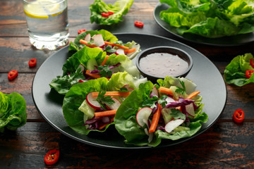 Vegetable lettuce wraps with carrot, onion, radish, red cabbage, cucumber and sweet chilli sauce