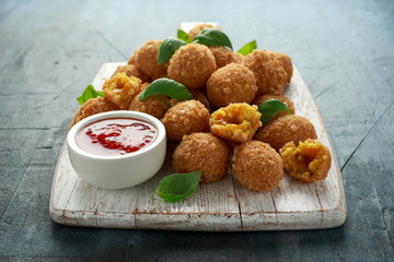 Fried Rice Balls with sweet hot sauce on wooden white board