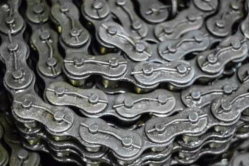 industrial background - rolled up drive chains in stock